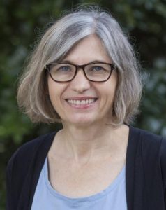 Portrait of Professor Jill Moore, a white woman with a chin length hair and glasses. 